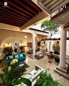 莫雷利亚M Hoteles Concepto的户外客厅配有蓝色的沙发和植物