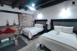 莫雷利亚M Hoteles Concepto的酒店客房,设有两张床和一张沙发