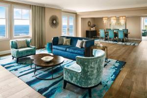 半月湾半月湾丽思卡尔顿酒店的客厅配有蓝色的沙发和椅子