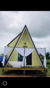 Ban Nong Khonสวนเบอร์รีแคมป์ทนายจุฬา Berry Camp Korat的白色天篷的小黄色房子