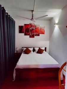 科伦坡Araliya Uyana Residencies Colombo - Entire House with Two Bedrooms的卧室配有一张墙上三幅画作的床