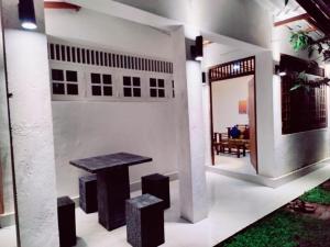 科伦坡Araliya Uyana Residencies Colombo - Entire House with Two Bedrooms的房屋内带桌子和凳子的房间