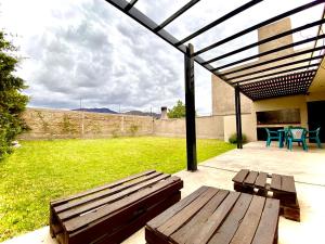 门多萨Vista Montaña的庭院设有木凳和桌子。