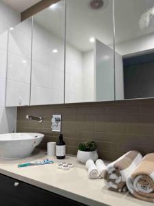 达尔文Sea Pearl Apartment at Waterfront的浴室配有盥洗盆和带毛巾的台面。