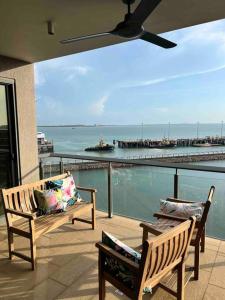 达尔文Sea Pearl Apartment at Waterfront的海景阳台上的2张长椅