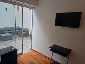 利马Habitación acogedora Aramburú的客厅配有沙发和墙上的电视