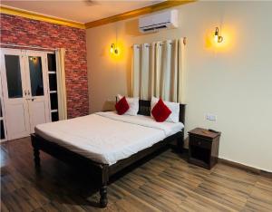 巴加Hotel Romeo's Place Near Baga Beach - 50 meters from Baga Beach的一间卧室配有一张带红色枕头的床