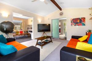 波里鲁阿Retro 4 bedroom home, warm and welcoming, quiet location的客厅配有两张沙发和一台电视机