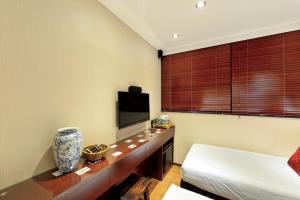 香港The Shai Red - formerly Mingle in The Shai的客房设有1张床、1台电视和1张桌子。