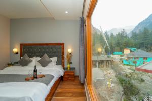 卡索尔Kasol ArtHouse - The Treasure of Himalayas的客房设有两张床和大窗户。