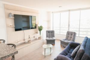 马尼萨莱斯El Mirador De Castilla的客厅配有沙发、椅子和电视