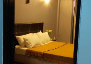 波德申2BR Apartment in Port Dickson Bayu Beach Resort的一间卧室配有一张带黄色床单和白色枕头的床。