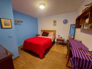 利马Habitación con baño privado acceso a cocina y terraza en Miraflores的一间卧室配有一张带红色毯子的床
