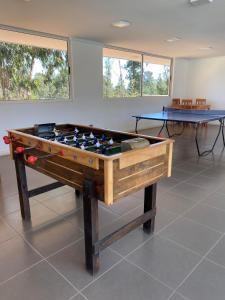 阿尔加罗沃Departamento en Algarrobo的一张乒乓球桌,位于一个配有两张桌子的房间