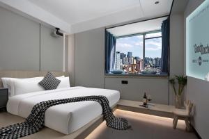 长沙沐沐酒店(长沙五一广场地铁站店)的卧室设有一张白色大床和一扇窗户。