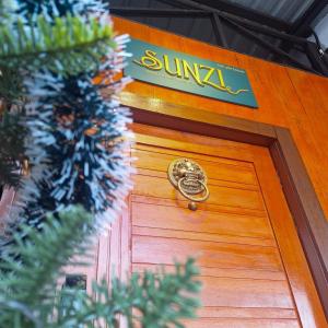 勿洞SUNZI BOUTIQUE HOSTEL : ซันซิ บูทีค โฮสเทล的木门,上面有标志