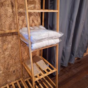 勿洞SUNZI BOUTIQUE HOSTEL : ซันซิ บูทีค โฮสเทล的木制架子上摆放着折叠毛巾