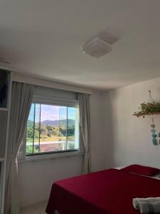 塞尔苏拉穆斯州长镇Ipê Palmas Hostel的一间卧室设有一张床和一个美景窗户。