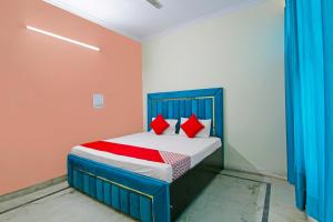 新德里OYO Flagship 81491 Delight Home Stay的一间卧室配有蓝色的床和红色枕头
