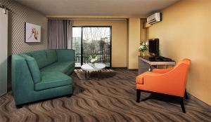 圣地亚哥小意大利波尔图维斯塔酒店的客厅配有绿色沙发和橙色椅子