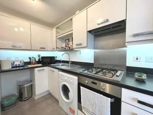 OakengatesGenesis 3 bedroom Home Telford- sleeps up to 5的厨房配有白色橱柜、洗衣机和烘干机
