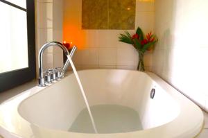 琅勃拉邦Namkhan View Luangprabang Resort的浴室内设有带水龙头的大型白色浴缸