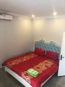 Phumĭ Chroŭy Svay‘The Greenhouse’ Nesat Village的一间卧室配有一张带红色毯子和红色枕头的床