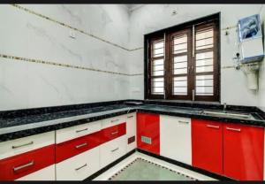 乌代浦7horses holidays homes的厨房配有红色和白色的橱柜和窗户