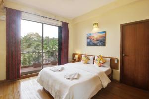 安君纳Genesis Leisure - Charming home-stays near Anjuna, Vagator & Assagao的一间卧室设有一张床和一个大窗户