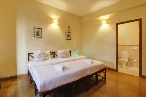 安君纳Genesis Leisure - Charming home-stays near Anjuna, Vagator & Assagao的一间带两张床的卧室和一间带卫生间的浴室