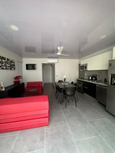 赫拉多拉Casa Mariposa的一间带红色沙发的客厅和一间厨房