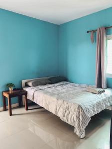 信武里府Parida Resort的蓝色卧室,配有床和桌子