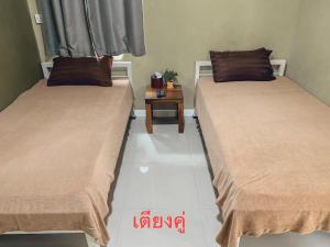 信武里府Parida Resort的两张睡床彼此相邻,位于一个房间里