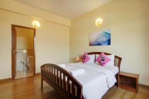 安君纳Genesis Leisure - Charming home-stays near Anjuna, Vagator & Assagao的卧室配有带粉红色枕头的大型白色床