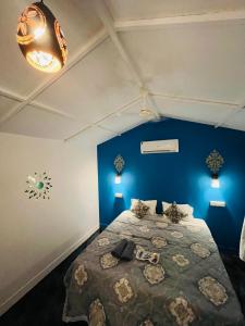 卡纳科纳LAKSHDEEP COTTAGES的一间卧室配有一张蓝色墙壁的床