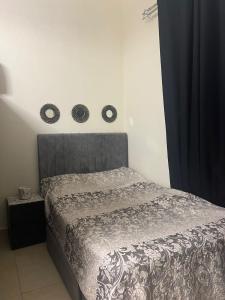 迪拜Al badaa的一间卧室配有一张带灰色床头板的床