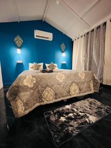 卡纳科纳LAKSHDEEP COTTAGES的一间卧室配有一张带棕色毯子的大床