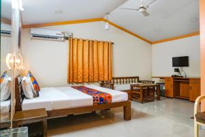 艾哈迈德讷格尔FabHotel Prime Vishwakirti Agri的一间卧室配有两张床和电视。
