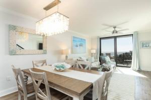 棕榈岛Shipwatch 418 - Luxury Oceanfront Penthouse in Isle of Palms的用餐室以及带桌椅的起居室。
