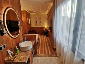 苏州枕窗听雨客栈（(苏州观前拙政园店）的一间带水槽和大镜子的浴室