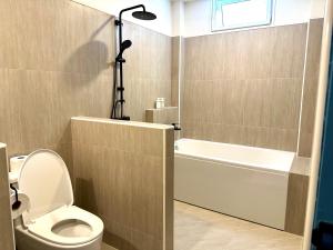 华欣Warm White Hua Hin House的浴室配有卫生间、浴缸和淋浴。