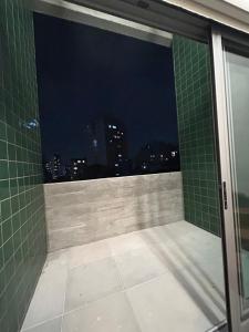 圣保罗Pinheiros Duplex no pool的一间晚上享有城市美景的浴室