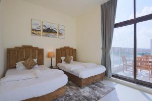 迪拜Fabulous 4br villa with Balcony的带阳台的客房内的两张床