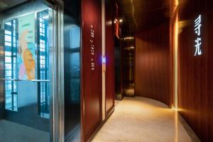 重庆寻光酒店(重庆两江幸福广场店)的带有玻璃门的建筑走廊