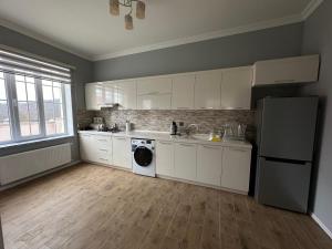 伊斯梅尔雷JLYN HOUSE的厨房配有白色橱柜、水槽和洗碗机。