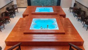 库塔Mahestu Hotel的带浴缸的客房内的大桌子