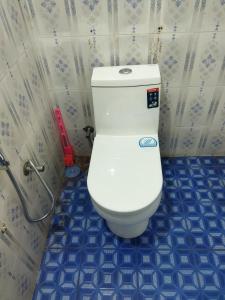 维特利PEARL HUT home stay vythiri Wayanad的浴室铺有蓝色瓷砖,设有白色卫生间。