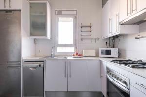 巴塞罗那Sunny Apt Barcelona 22@的白色的厨房配有水槽和微波炉