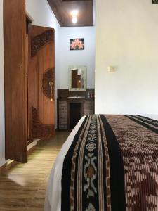 姆杜克Umah De Madya & Rooftop De Madya的一间卧室配有一张床、一个壁炉和一个镜子