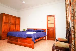科伦坡The Anam Hotel - Wellawatte的一间卧室配有一张带蓝色床单和木制橱柜的床。